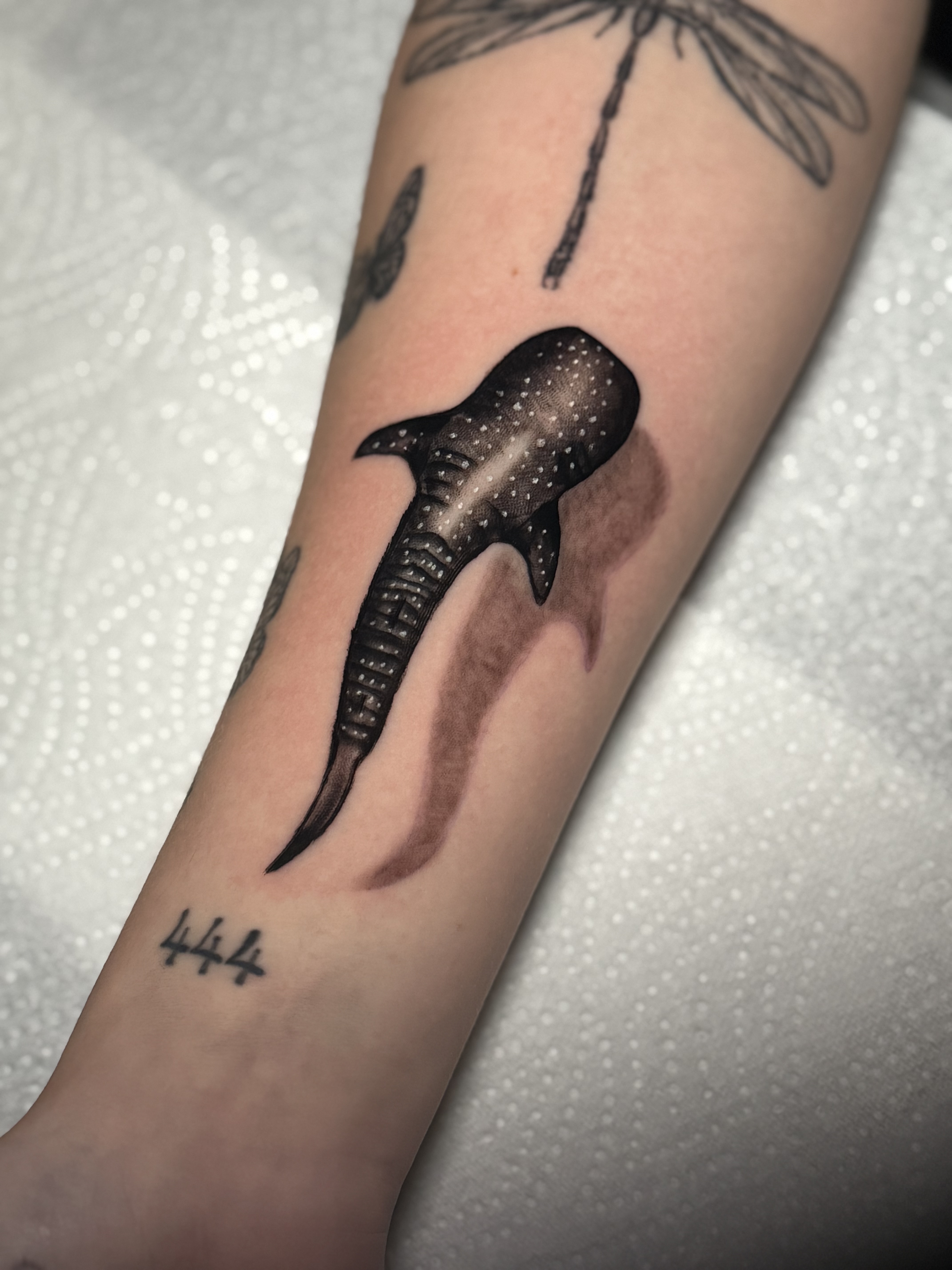 Black and grey whale shark tattoo on the forearm with dotted pattern and soft shadow